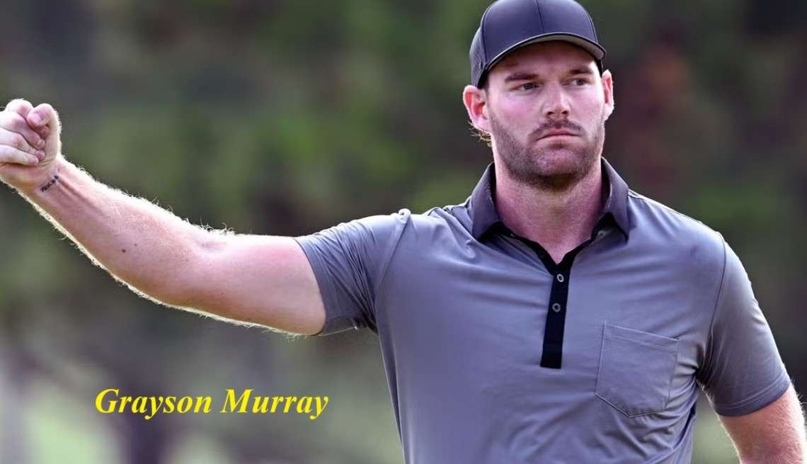 A golfer in a gray polo shirt raises his fist, focused and determined, during a game.